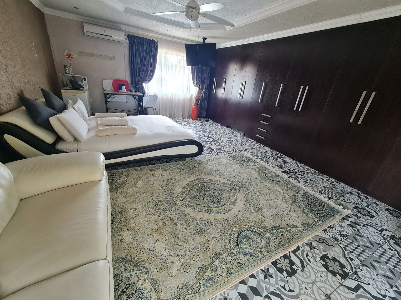 Beulah Presidential Suite luxury bedroom with king-size bed and elegant lighting at Quereba Bed and Breakfast Mafikeng.