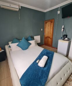 Sapphire Standard Suite cool blue bedroom with modern furniture and calm lighting at Quereba Bed and Breakfast Mafikeng.
