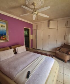 Diamond Deluxe Suite bedroom with warm tones, queen bed, and nearby pool access at Quereba Bed and Breakfast Mafikeng.