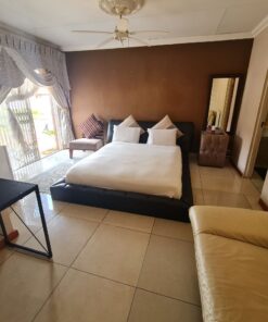 Star Ruby Deluxe Suite luxury bedroom with bold red accents and elegant bedding at Quereba Bed and Breakfast Mafikeng.
