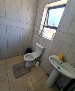 Opal Suite private bathroom with white tiles and bright vanity inside Quereba Guesthouse Mafikeng.