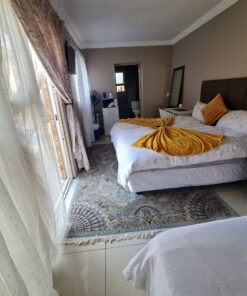 Onyx Family Suite large family bedroom with twin and double beds overlooking garden area at Quereba Bed and Breakfast Mafikeng.