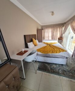 Onyx Family Suite large family bedroom with twin and double beds overlooking garden area at Quereba Bed and Breakfast Mafikeng.