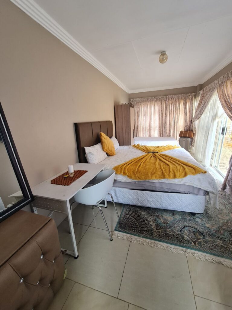 Onyx Family Suite large family bedroom with twin and double beds overlooking garden area at Quereba Bed and Breakfast Mafikeng.