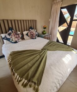 Garnet Standard Suite cozy bedroom with warm colors and garden-side view at Quereba Bed and Breakfast Mafikeng.