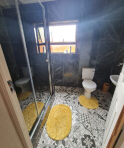 Opal Suite private bathroom with white tiles and bright vanity inside Quereba Guesthouse Mafikeng.