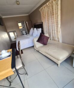 Amethyst Family Suite bedroom with double bed, cozy decor, and garden view at Quereba Bed and Breakfast Mafikeng.