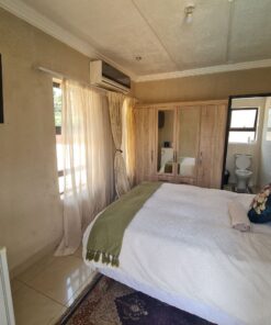 Garnet Standard Suite cozy bedroom with warm colors and garden-side view at Quereba Bed and Breakfast Mafikeng.