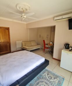 Star Ruby Deluxe Suite luxury bedroom with bold red accents and elegant bedding at Quereba Bed and Breakfast Mafikeng.