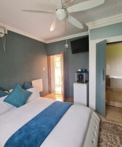 Sapphire Standard Suite cool blue bedroom with modern furniture and calm lighting at Quereba Bed and Breakfast Mafikeng.