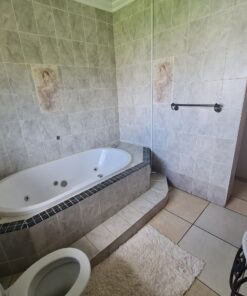 Emerald Suite bathroom with clean tiles at Quereba BnB Mafikeng.